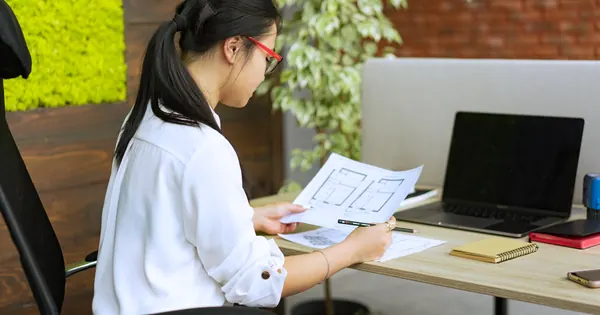 Examen d’un plan imprimé à côté d’un ordinateur portable