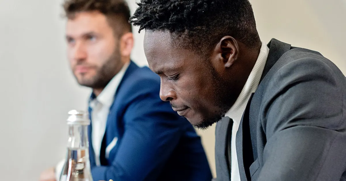 Professionnels examinant un contrat et des documents dans un bureau.