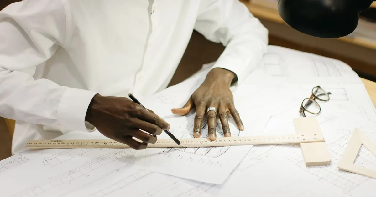 Professionnel examinant un plan avec une règle et un crayon