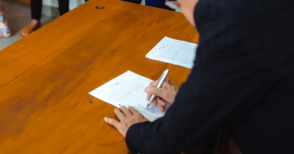 Signature d’un dossier administratif à une table