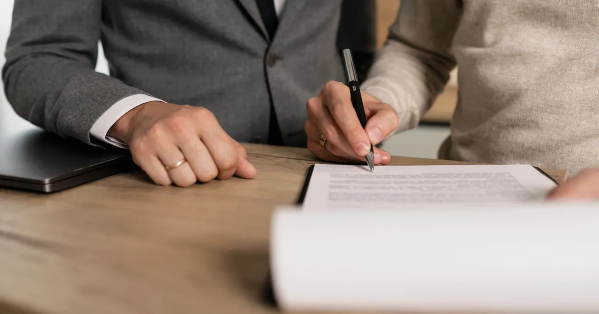 Vérification d’un document sur une table, stylo en main