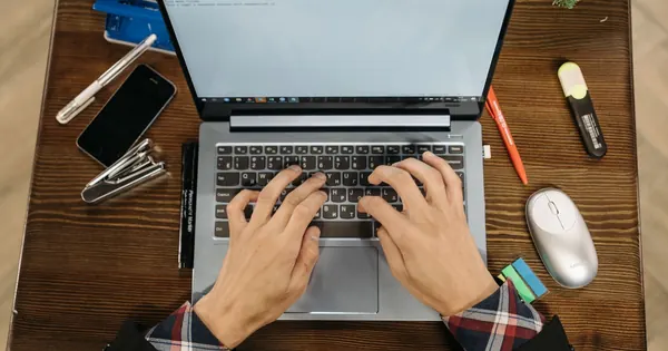 Saisie sur un ordinateur portable au clavier sobre, sur une table de travail