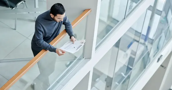 Professionnel examinant des documents de travail dans un bureau lumineux.