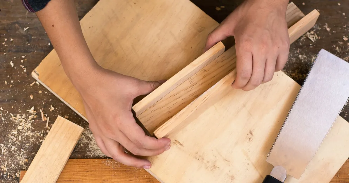 Mains au travail sur un assemblage en bois