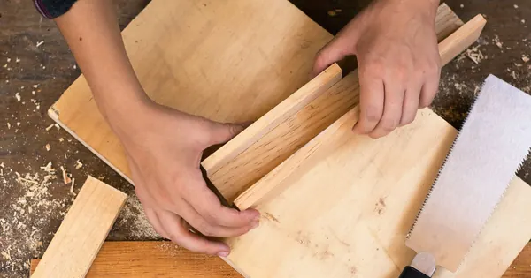 Mains au travail sur un assemblage en bois