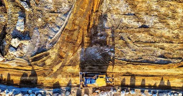 Engin de terrassement sur un terrain de chantier vu du dessus