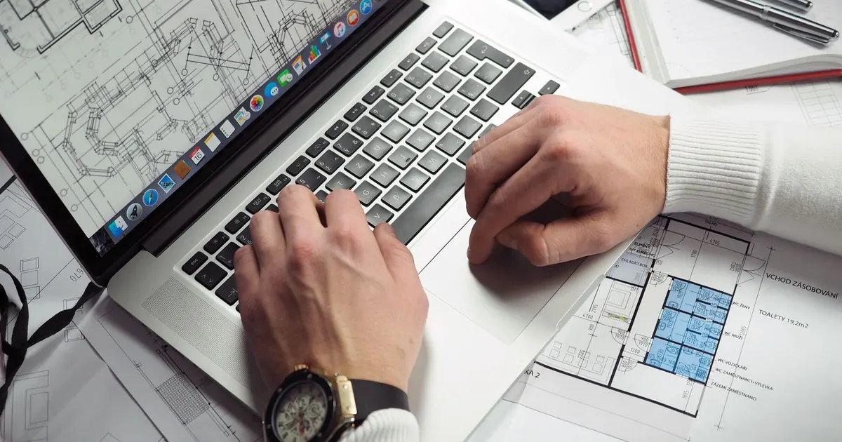 Consultation de plans sur une table avec un ordinateur