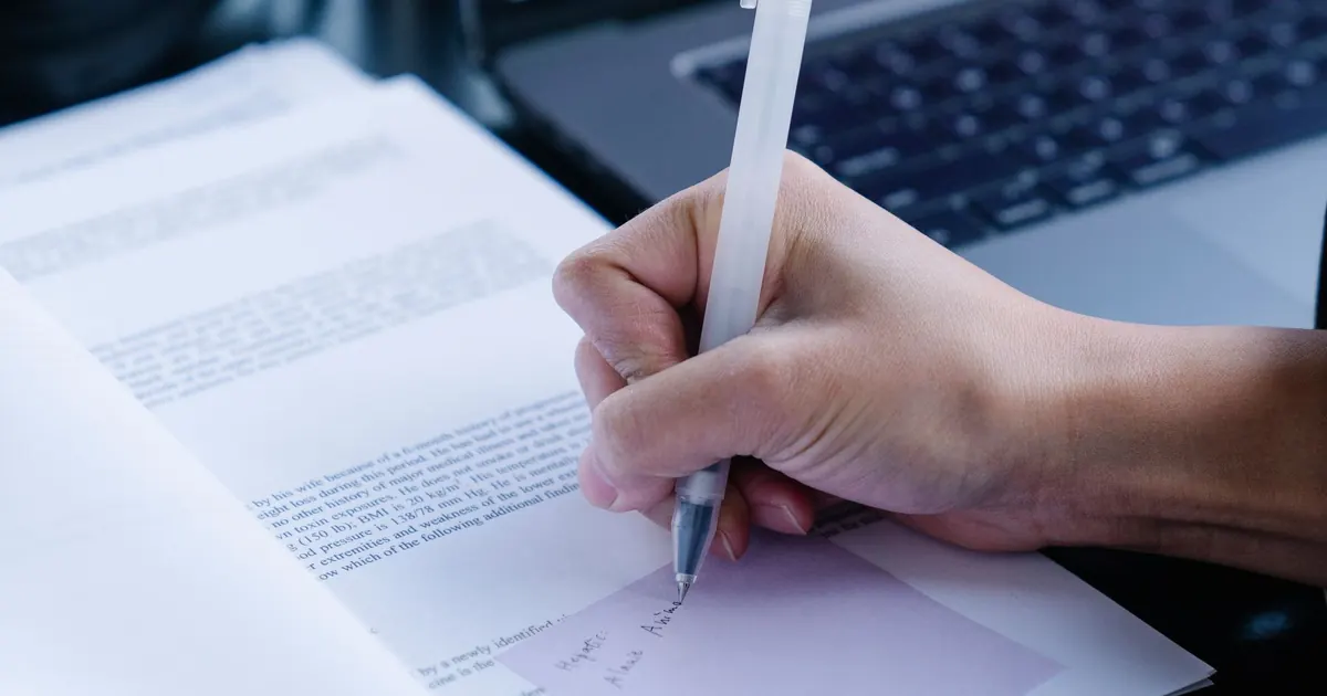 Prise de notes sur des documents près d’un ordinateur